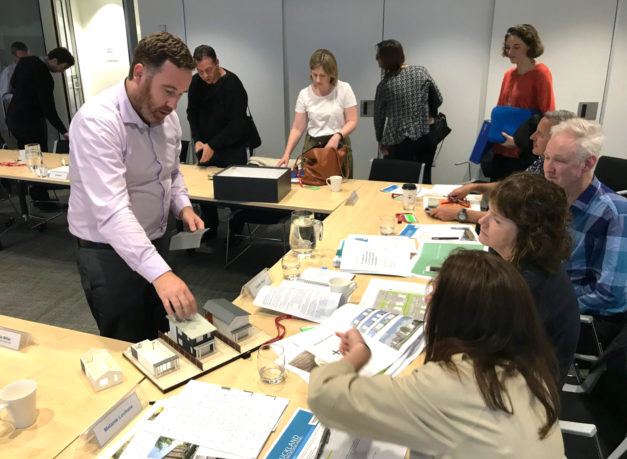 Auckland Urban Design Panel photo with people in an office environment discussing housing models