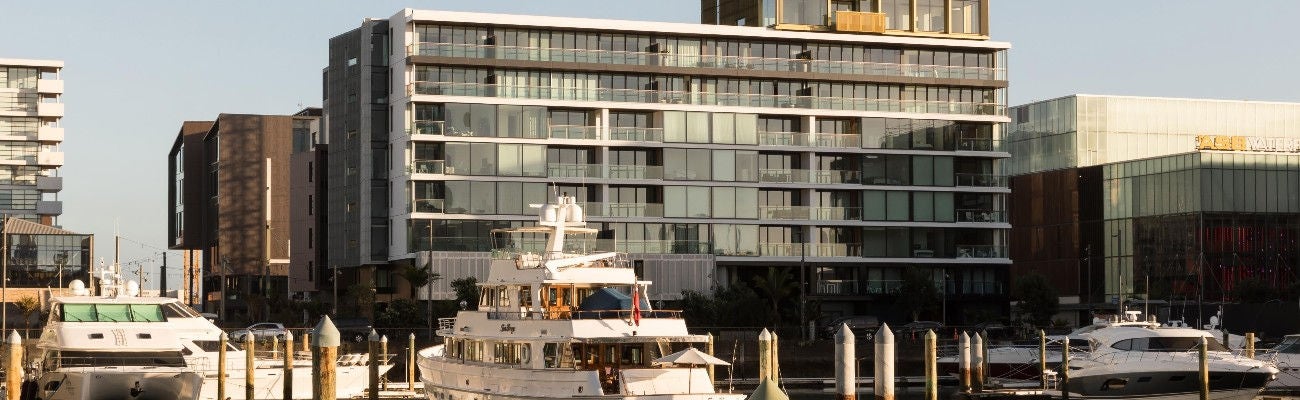 132 Halsey sits in the heart of Wynyard Quarter, Auckland’s waterfront area, 2 motorboats in the foreground, with the apartment block behind.