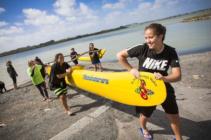 A group of wahine pull a waka with the name "Matukutururu" on the bow from the Waitemata harbour.